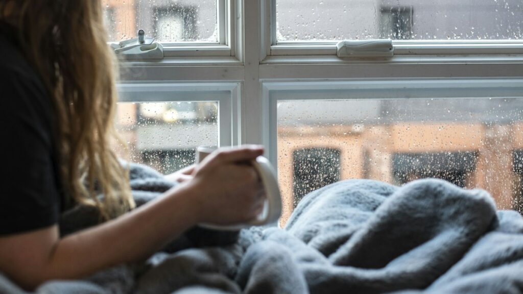 Mujer sentada junto a una ventana